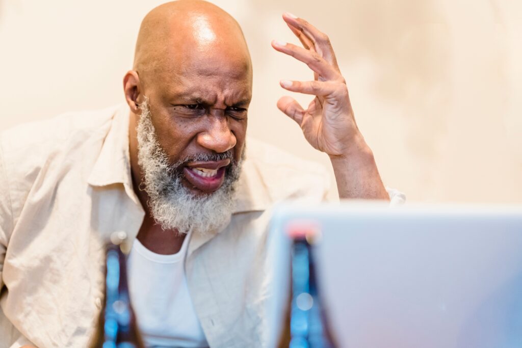 A frustrated migrant looking at German apartment listings on a laptop screen to escape the Anmeldung trap Germany