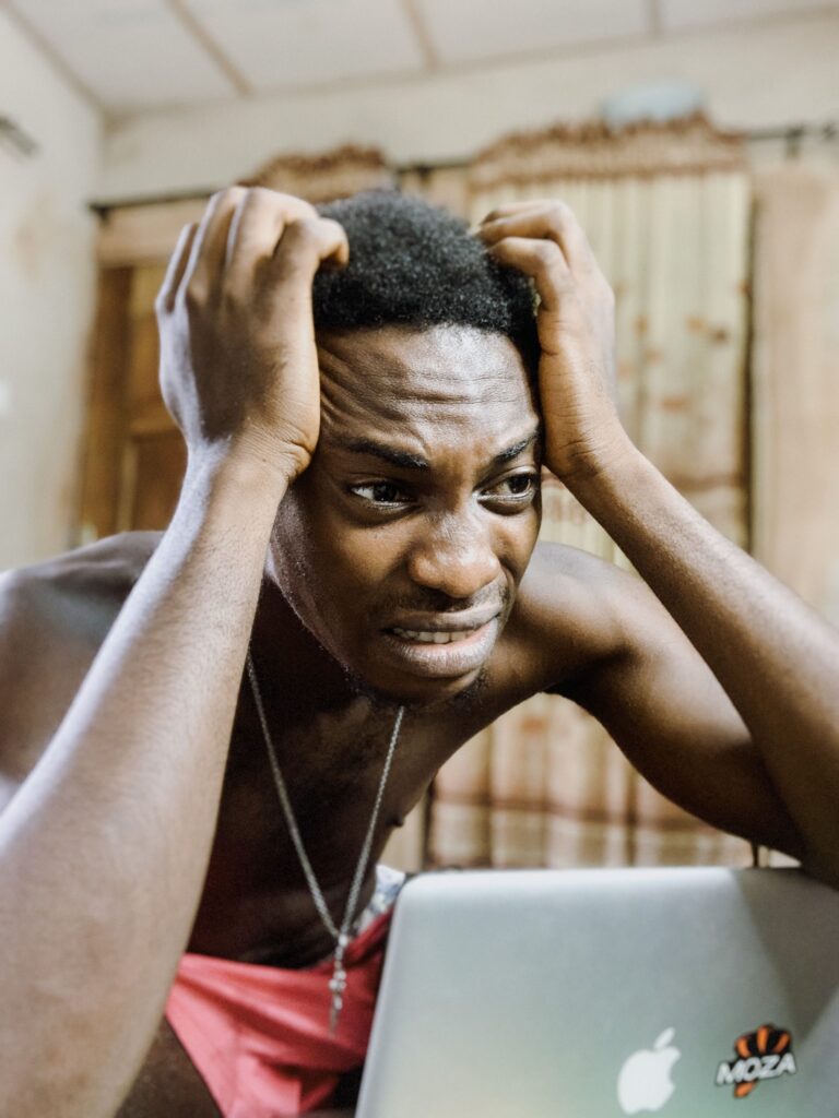 A frustrated migrant looking at German apartment listings on a laptop screen to escape the Anmeldung trap Germany